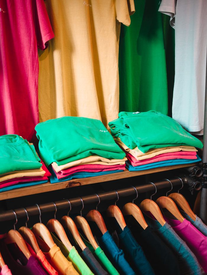About Vibrant and neatly organized closet with colorful t-shirts folded and hanging.